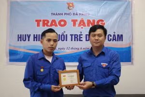 Anh Lê Công Hùng - Phó Bí thư Thành đoàn Đà Nẵng thừa ủy quyền của Trung ương Đoàn, đã trao Huy hiệu “Tuổi trẻ dũng cảm” cho đoàn viên Phan Thanh Phú. Ảnh: Thành đoàn Đà Nẵng. 