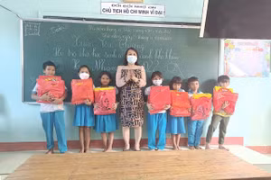 Cô Nguyễn Thị Hồng Thanh – Phó Hiệu trưởng Trường trường phổ thông dân tộc bán trú Tiểu học và THCS Trần Phú, trao quà cho các em học sinh khó khăn. 