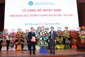 Thứ trưởng Hoàng Minh Sơn (phải) tặng hoa chúc mừng GS.TS Trần Thanh Hải tiếp tục được giữ chức vụ Hiệu trưởng Trường ĐH Mỏ - Địa chất. Ảnh: Đình Tuệ.