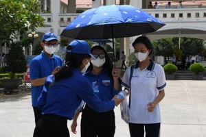 Lực lượng tình nguyện viên tại điểm thi Trung học phổ thông Đông Thạnh phát nước cho thí sinh sau khi kết thúc môn thi thứ 2 kỳ thi tốt nghiệp THPT.