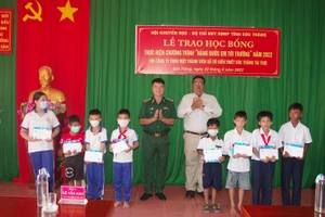 Đại diện lãnh đạo BĐBP tỉnh và Hội khuyến học tỉnh Sóc Trăng trao học bổng cho các em học sinh.