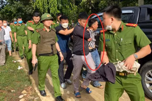 Lực lượng công an áp giải nghi phạm Mạc Văn Dục.