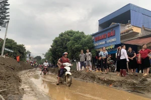 Bùn đất theo lũ trôi về tràn ngập trên Quốc lộ 279. (Ảnh Hồng Ninh/TTXVN).