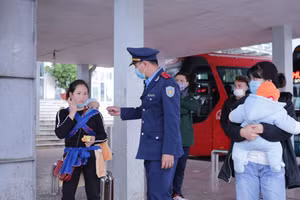 Lực lượng chức năng tuyên truyền nhắc nhở người dân đeo khẩu trang đúng cách tại bến xe khách Lai Châu để phòng chống dịch COVID - 19. (Ảnh: Quý Trung/TTXVN).