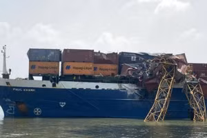 Chiếc cần cẩu gãy đôi, một phần rơi xuống trúng vào các thùng container trên tàu.