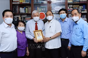 Chủ tịch nước Nguyễn Xuân Phúc đến thăm hỏi và tặng quà cho nhà báo Đặng Minh Phương, từng làm việc ở ba tờ báo của Đảng: Cứu quốc Nam Trung Bộ, Cờ Giải phóng và Nhân Dân. Ảnh: TTXVN