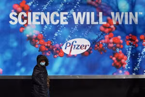 Một người đi ngang qua trụ sở Manhattan của Pfizer ở thành phố New York.