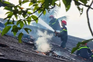 Cảnh sát leo lên mái ngói xưa tại Tòa nhà Trưng bày hiện vật thời kháng chiến chống Pháp, Bảo tàng Lịch sử Thừa Thiên - Huế để dập lửa.