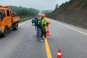 Công nhân đang sơn kẻ vạch và các việc khác trong gói hệ thống an toàn được bổ sung cho cao tốc Cam Lộ - La Sơn. (Ảnh: N.V)