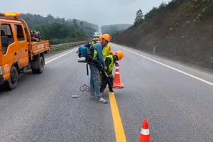 Công nhân đang sơn kẻ vạch và các việc khác trong gói hệ thống an toàn được bổ sung cho cao tốc Cam Lộ - La Sơn. (Ảnh: N.V)