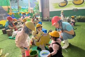 Trẻ lớp nhà trẻ 36 tháng Trường Mầm non Ngọc Lan tham gia trải nghiệm làm thợ sơn, xây dựng công viên khủng long ngay tại khu vực trường.