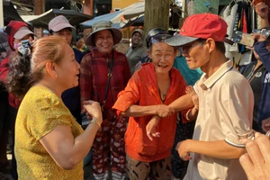 Hàng xóm vui mừng đón anh Chung (đội mũ đỏ) trở về quê sau 18 năm lưu lạc ở Trà Vinh. 