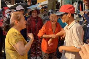 Hàng xóm vui mừng đón anh Chung (đội mũ đỏ) trở về quê sau 18 năm lưu lạc ở Trà Vinh. 