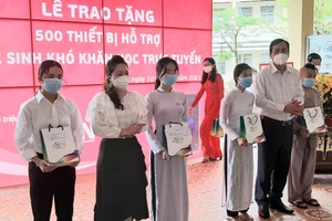 Lãnh đạo tỉnh Cà Mau trao thiết bị học trực tuyến cho HS hoàn cảnh khó khăn. Ảnh: T.Sắc.