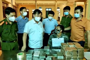 Lầu A Di (ngồi giữa) cùng tang vật bị thu giữ