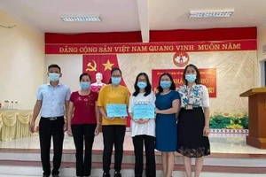 Hai học sinh giỏi (đứng giữa) chụp ảnh cùng cán bộ phường Đồng Tâm