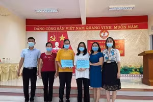 Hai học sinh giỏi (đứng giữa) chụp ảnh cùng cán bộ phường Đồng Tâm