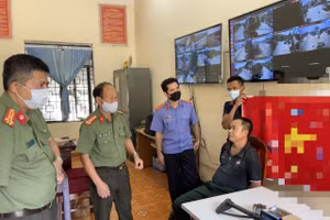 Đối tượng Lương Văn Định (áo đen) cùng tang vật thu giữ tại cơ quan Công an.