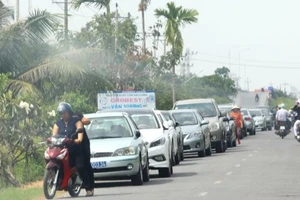 Người dân ấp Trà Vôn A “mãn nhãn” với đoàn xe công tập trung về xã Vĩnh Tân (thị xã Vĩnh Châu, Sóc Trăng) đi ăn giỗ. Ảnh: C.Quốc