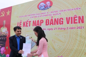 Đồng chí Nguyễn Quang Đông, Bí thư Chi bộ Văn phòng Đoàn trường ĐH Y - Dược (ĐH Thái Nguyên) trao quyết định kết nạp cho Đảng viên mới.