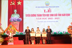 Thứ trưởng Phạm Ngọc Thưởng (bìa phải) và Bí thư Tỉnh ủy Nam Định Phạm Gia Túc tặng Bằng khen của Bộ GD&ĐT cho các em học sinh tiêu biểu xuất sắc của tỉnh Nam Định. 