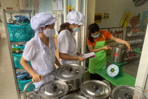 Đến giờ ăn, nhân viên nuôi dưỡng tại Trường Mầm non Phú La (Hà Đông, Hà Nội) chia cơm và thức ăn tới từng lớp. 