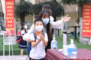Học sinh thực hiện sát khuẩn tay và đeo khẩu trang khi tới lớp để phòng dịch Covid-19. 