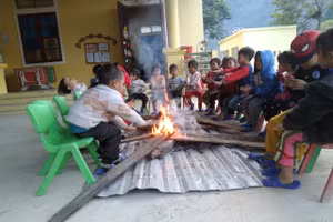 Trẻ sưởi ấm trong giờ ra chơi tại điểm bản Piêng Cọc, Trường Mầm non Mai Sơn (huyện Tương Dương, Nghệ An). Ảnh: NTCC