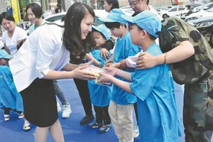 Cô giáo Wang Xinhui, Giám đốc Trung tâm Phục hồi chức năng Star Road, Trung Quốc, trao quà cho trẻ tự kỷ.