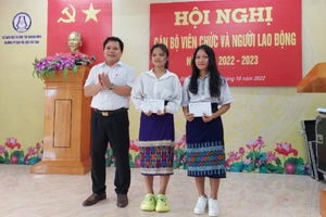 Hiệu trưởng Trường PTDTNT Quảng Bình Phạm Hồng Việt trao quà của Bí thư Tỉnh ủy Vũ Đại Thắng đến em Cao Thị Lệ Hằng và em Vũ Thị Lích.