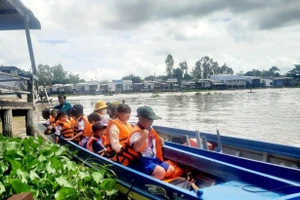 Học sinh vùng lũ huyện An Phú (An Giang) được đưa rước đến trường. Ảnh: T. Nhân