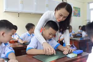 Giáo viên Trường Tiểu học Nam Hà hướng dẫn học sinh lớp 1 cách cầm phấn.