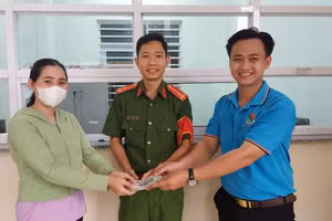 Công an phường 6 và em Nguyễn Minh Toàn bàn giao lại chiếc ví cho chị Lê Thị Huỳnh Oanh. Ảnh: NVCC.