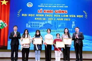 PGS.TS Bùi Huy Nhượng - Phó Hiệu trưởng và PGS.TS Phạm Quang - Trưởng khoa Đại học Tại chức trao giấy khen và tặng hoa chúc mừng cho các tân sinh viên.