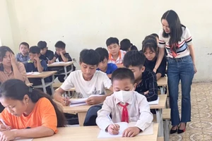 Giáo viên quan tâm, tạo hứng thú học tập trên lớp là biện pháp hiệu quả giúp học sinh hào hứng đến trường. Ảnh: Cô Vi Thị Ỏn và học sinh trong lớp học.