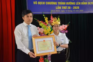 Ông Bùi Văn Linh - Vụ trưởng Vụ Giáo dục Chính trị và công tác HSSV trao bằng khen của Bộ trưởng Bộ GD&ĐT cho Nguyễn Thị Thu Hằng.