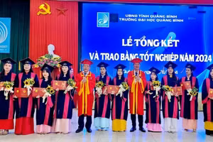 Lãnh đạo Trường đại học Quảng Bình trao bằng tốt nghiệp cho sinh viên.