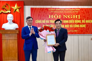 Chủ tịch UBND tỉnh Quảng Bình trao quyết định và chúc mừng Giám đốc Sở Khoa học và Công nghệ Nguyễn Trần Quang.