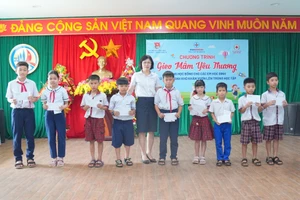 Bà Bùi Thị Hồng Nhung, Phó Giám đốc Công ty TĐQT trao quà đến học sinh.