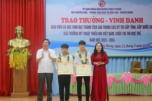 TS Lê Thị Hương, Giám đốc Sở GD&ĐT tỉnh Quảng Trị; ông Nguyễn Hữu Ngọc, Phó Bí thư Thường trực Huyện ủy Triệu Phong tặng Bằng khen của UBND tỉnh cho 2 học sinh.