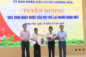 Ông Trần Bình Thuận, Chủ tịch UBND huyện (bên trái) và ông Phạm Trọng Hổ, Phó Chủ tịch UBND huyện đã biểu dương và tặng giấy khen cho hai học sinh Hồ Thị Hinh và Hồ Thị Nhỉ.