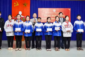 Ông Nguyễn Công Huấn, Phó Chủ tịch Thường trực HĐND tỉnh Quảng Bình (bên phải) trao học bổng đến học sinh. 