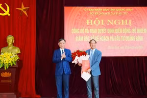 Ông Trần Thắng, Chủ tịch UBND tỉnh Quảng Bình trao quyết định và tặng hoa chúc mừng Giám đốc Sở Kế hoạch và Đầu tư Nguyễn Xuân Đạt.