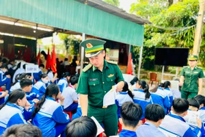 Đồn Biên phòng CKQT Lao Bảo phát tờ rơi đến học sinh về phòng, chống ma túy. Ảnh: Văn Sáu