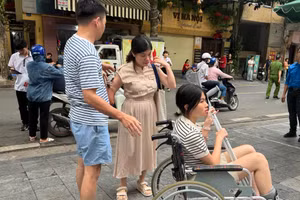 Thí sinh gãy chân được cán bộ làm công tác thi hỗ trợ đưa vào trường thi sau khi phụ huynh đưa đến.