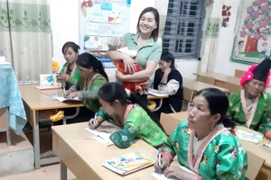 Cô Vừ Thị Pa, giáo viên Trường PTDTBT Tiểu học và THCS Tênh Phông bế con cho học viên học bài. Ảnh NVCC.