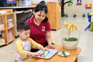 Cô giáo Trường Mầm non Tân Mai đang hướng dẫn học sinh gọt rau quả. Ảnh NTCC.