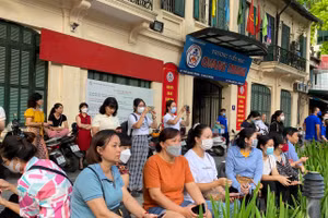 Phụ huynh ngồi chờ con trong buổi thi đầu tiên. Ảnh Ngô Chuyên.