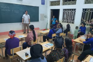 Thầy Nguyễn Văn Quỳnh - Hiệu trưởng Trường Phổ thông DTBT Tiểu học Tân Tiến cùng trao đổi với học viên lớp xoá mù chữ. Ảnh NVCC.