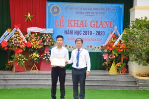 Thầy Phạm Đình Kha, Hiệu trưởng Trường THPT Võ Chí Công (bìa phải) trao thưởng cho HS có thành tích xuất sắc trong học tập